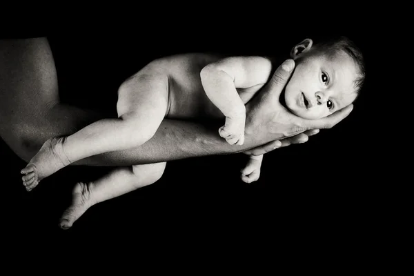 Bebé niña en padres brazos aislados en negro —  Fotos de Stock