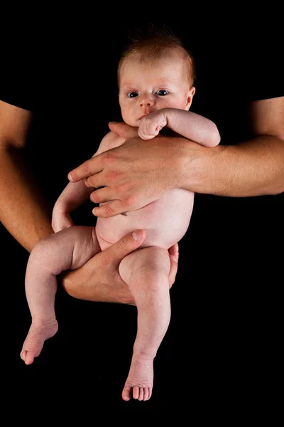 Menina infantil em pais braços isolados em preto — Fotografia de Stock