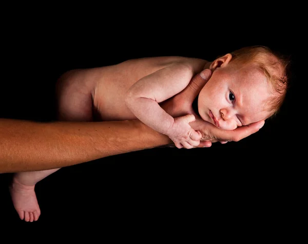 Infant girl on fathers arms isolated on black Stock Photo