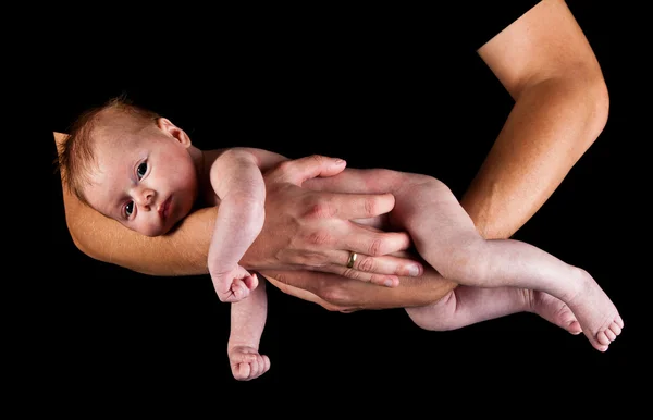 Infant girl on fathers arms isolated on black Stock Image
