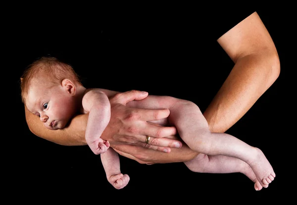 Infant girl on fathers arms isolated on black Royalty Free Stock Images