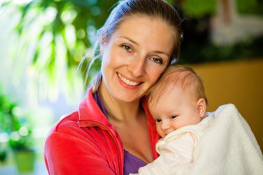 Mother holding beautiful baby girl clipart