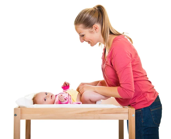 Madre cambiando pañal de niña en la mesa del vivero —  Fotos de Stock