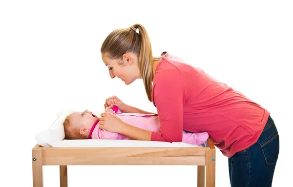Mamma che cambia il pannolino della bambina sul tavolo della scuola materna — Foto Stock