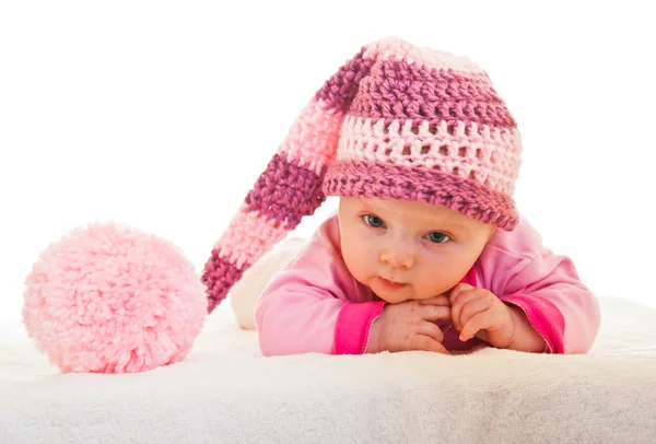 Infant baby girl raising head in funny hat isolated on white — Stock Photo, Image