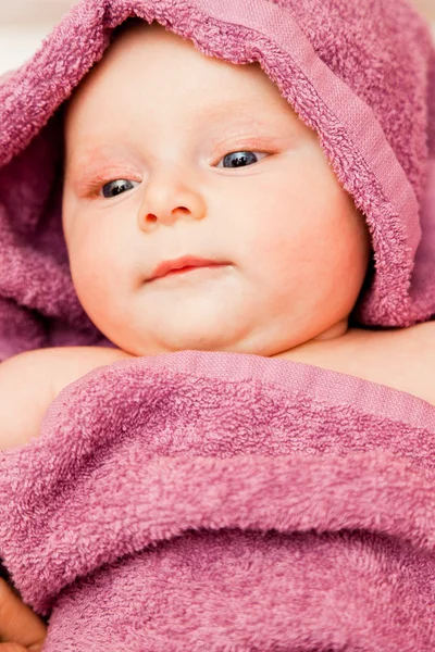 Bebé niña sonriendo acostado en toalla violeta —  Fotos de Stock