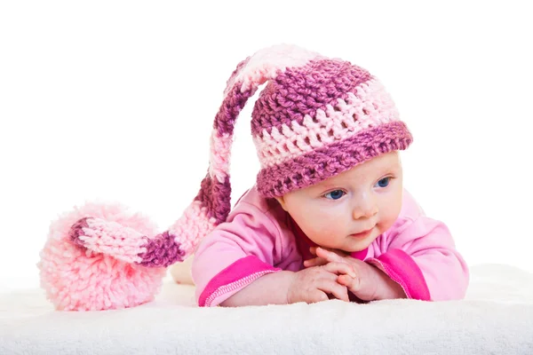 Infant baby girl raising head in funny hat isolated on white — Stockfoto