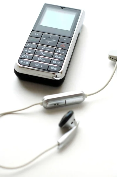 Mobilní telefon a sluchátka — Stock fotografie