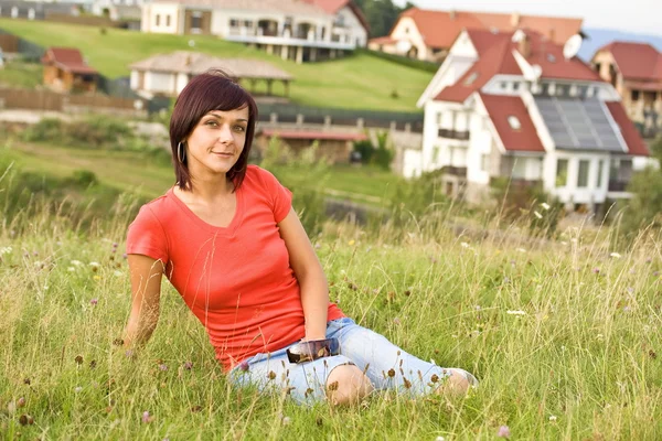 Vrouw zittend in het gras — Stockfoto