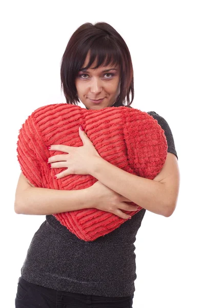 Donna abbracciare un cuscino a forma di cuore — Foto Stock