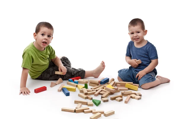 Jungen spielen mit weißen Blöcken — Stockfoto