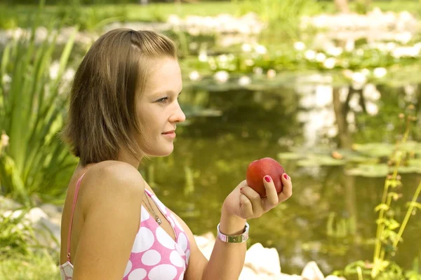 Flicka som håller en persika — Stockfoto