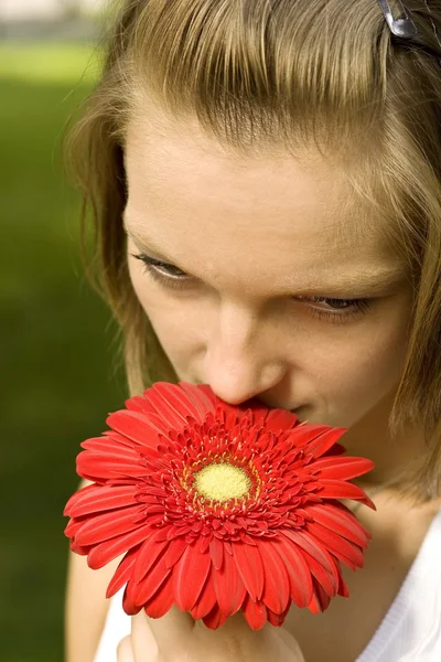 Kırmızı bir çiçek tutan kadın — Stok fotoğraf