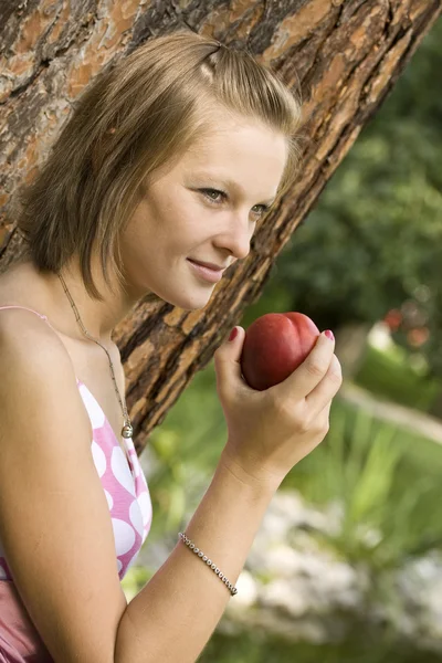 Девушка держит персик — стоковое фото