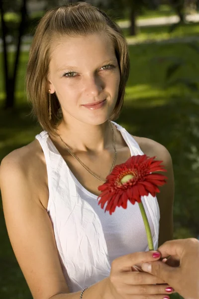 Kvinna med en röd blomma — Stockfoto