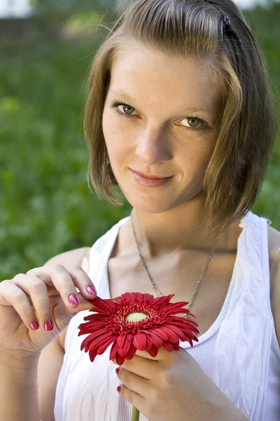 Mujer sosteniendo una flor roja — Foto de Stock