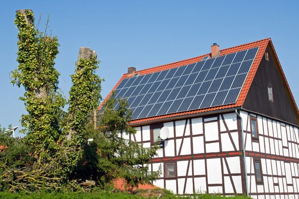 Casa de moldura velha com células solares no telhado — Fotografia de Stock
