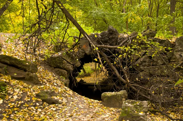 Stone grotto in autumn park — Stock Photo, Image