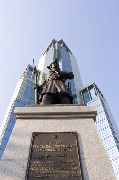 Памятник русскому солдату на фоне офиса — стоковое фото