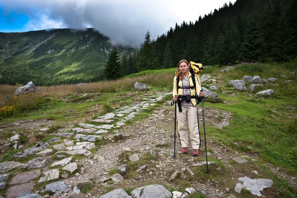 Backpacker-Mädchen erkundet die Berge. — Stockfoto