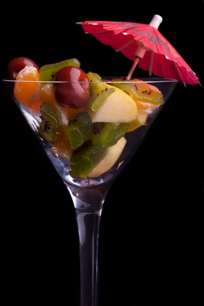 Copo com salada de frutas em fundo preto — Fotografia de Stock