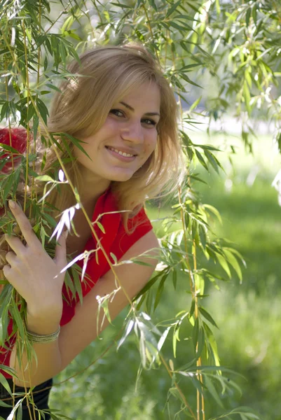 Portrait of the girl in a red blouse which smiles — Stock Photo, Image
