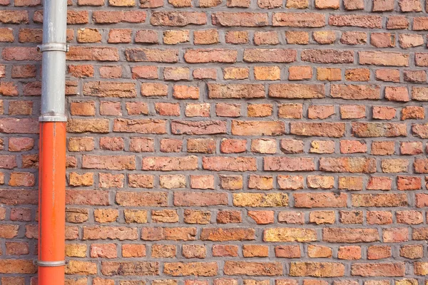 Mur de briques rouges avec tuyau de gouttière — Photo