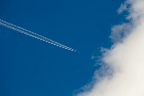 Avião, caminho de condensação e nuvem — Fotografia de Stock