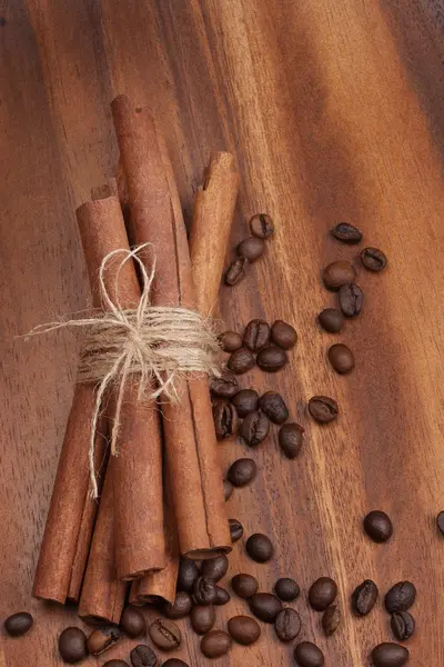Canela y granos de café sobre mesa de madera — Foto de Stock