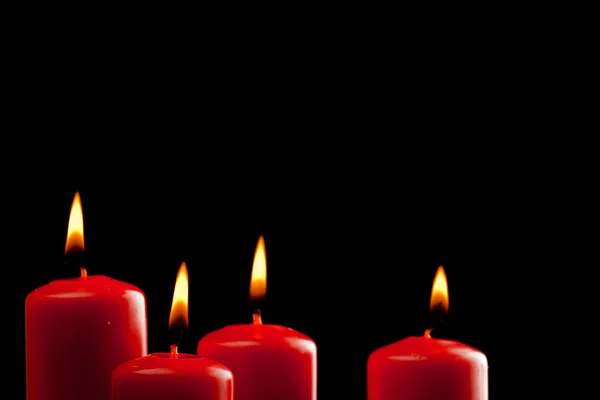 Quattro candele rosse su nero — Foto Stock