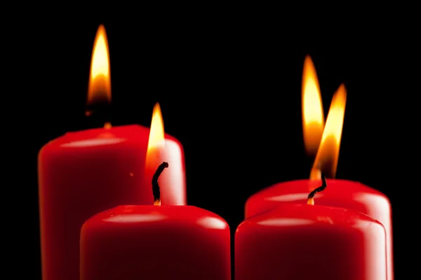 Čtyři červené svíčky nad černou — Stock fotografie