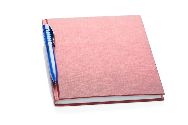 Перо над красным дневником — стоковое фото