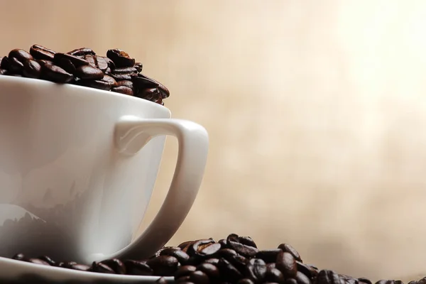 Csésze kávé babbal, sárga háttér — Stock Fotó