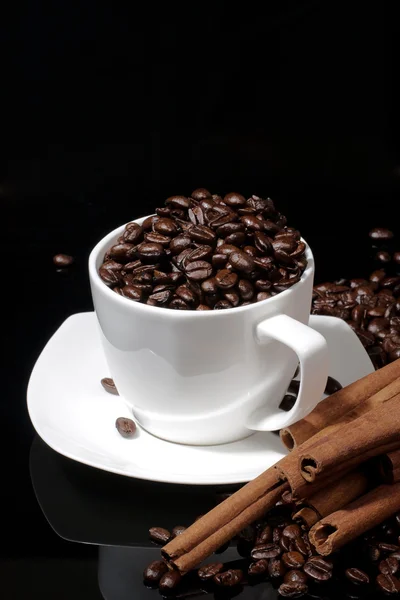 Cup with coffee beans on dark background — Stock Photo, Image