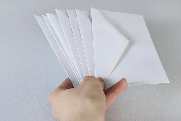 Mão feminina segurando um envelopes sobre fundo branco. Não isola — Fotografia de Stock
