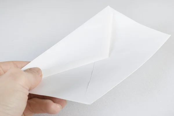 Mão feminina segurando um envelope sobre fundo branco. Não isola — Fotografia de Stock