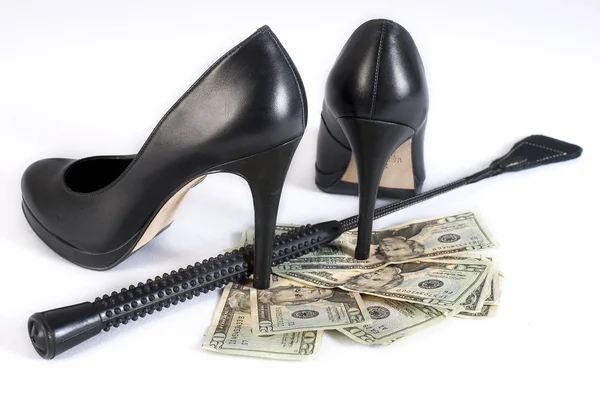 Frusta di Flogging in pelle nera, scarpe tacchi alti e soldi — Foto Stock