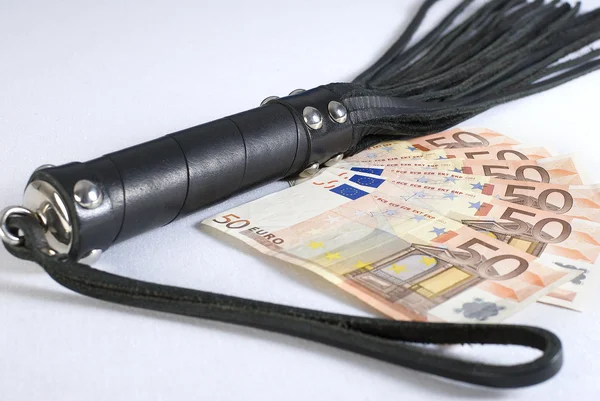 Peitsche aus schwarzem Leder und Geld auf weißem Hintergrund. — Stockfoto