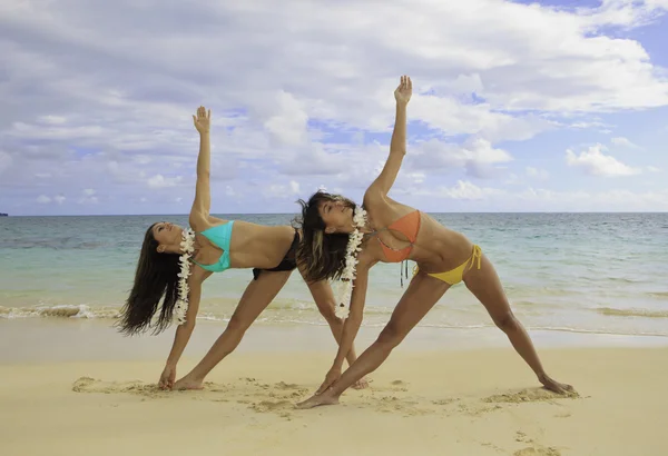 Twee meisjes doen yoga op het strand — Stockfoto