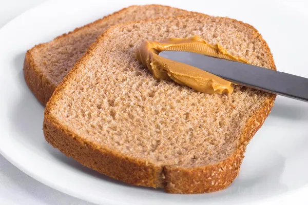 Manteiga de amendoim e pão de trigo inteiro — Fotografia de Stock