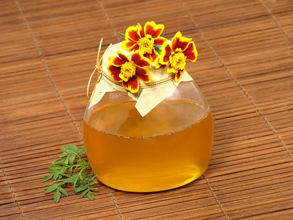 Sklenici s medem a žluté květy. — Stock fotografie