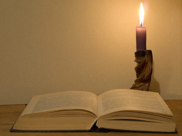 Ανοιχτό βιβλίο και λαμπερό κερί. — Φωτογραφία Αρχείου
