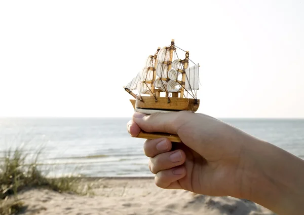 Mann hält Miniaturschiff in der Hand — Stockfoto