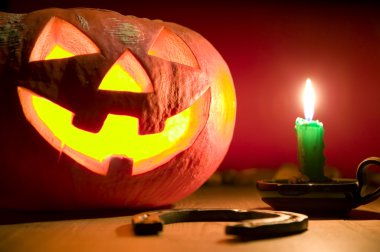 Creepy pumpkin near candle, halloween concept clipart