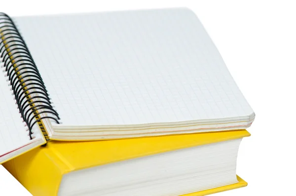 Closeup shot of opened yellow copybook on book. — Stock Photo, Image