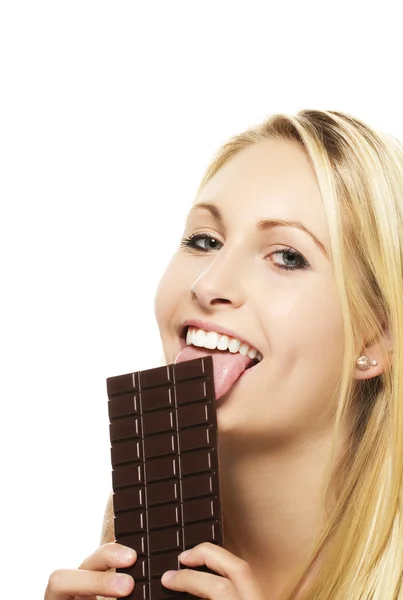 Mulher loira bonita lambendo em uma barra de chocolate — Fotografia de Stock