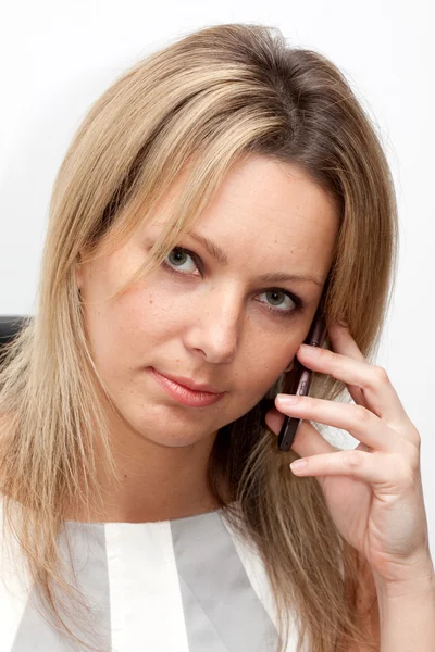Porträt einer blonden Frau in weißer Bluse mit Handy Stockbild
