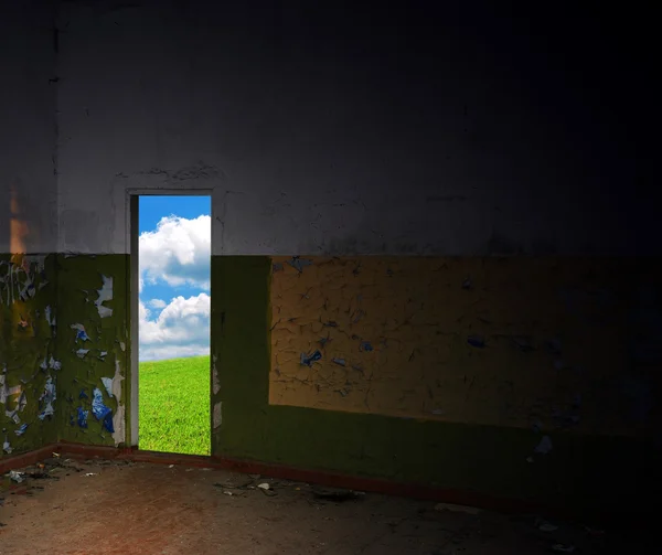 Chambre vide abandonnée avec sortie vers prairie verte — Photo