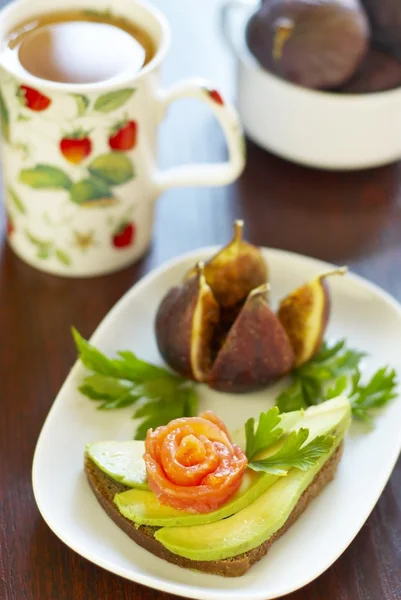 Sandwich with avocado and salmon, figs and tea — Stock Photo, Image