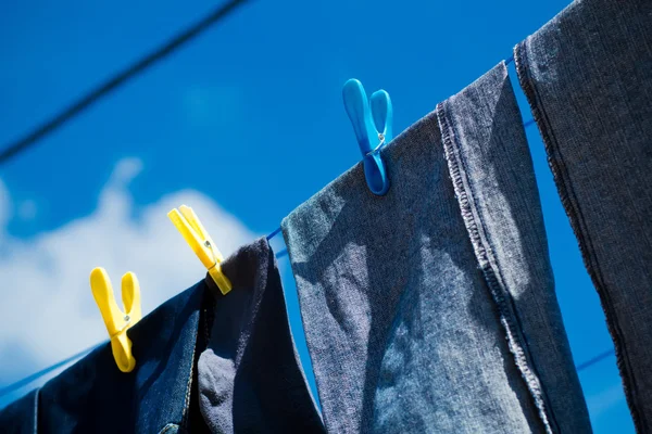 Выстиранные синие джинсы высыхают снаружи — стоковое фото
